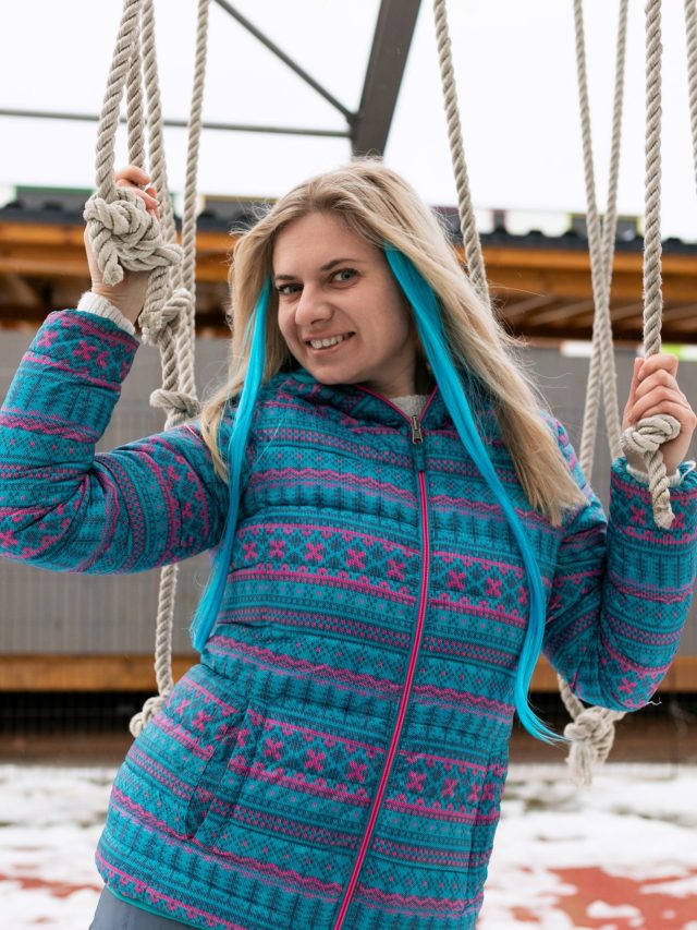 European woman with blond hair enjoys a day off while walking on the street in winter